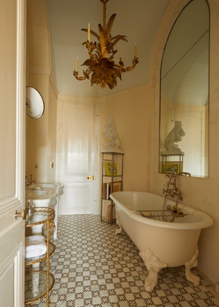 Image may contain Chandelier Lamp Bathing Bathtub Person Tub Floor Indoors Interior Design Sink and Candle